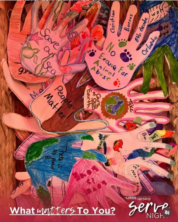 Colorful paper handprints are layered together, featuring various messages about community and environmental concerns.