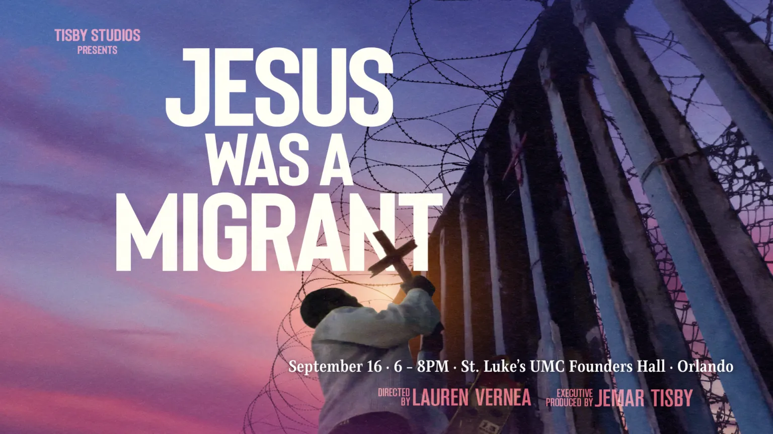 A person holds a cross near a border wall, with the text "JESUS WAS A MIGRANT" prominently displayed above.
